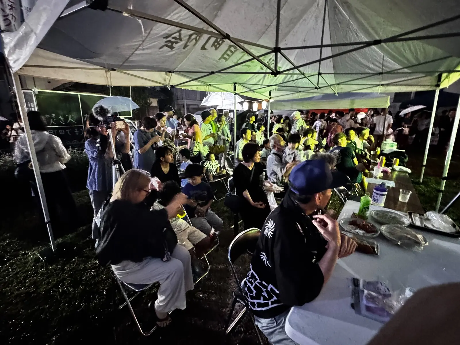 夜のテントの下でにぎわう夕涼み会会場